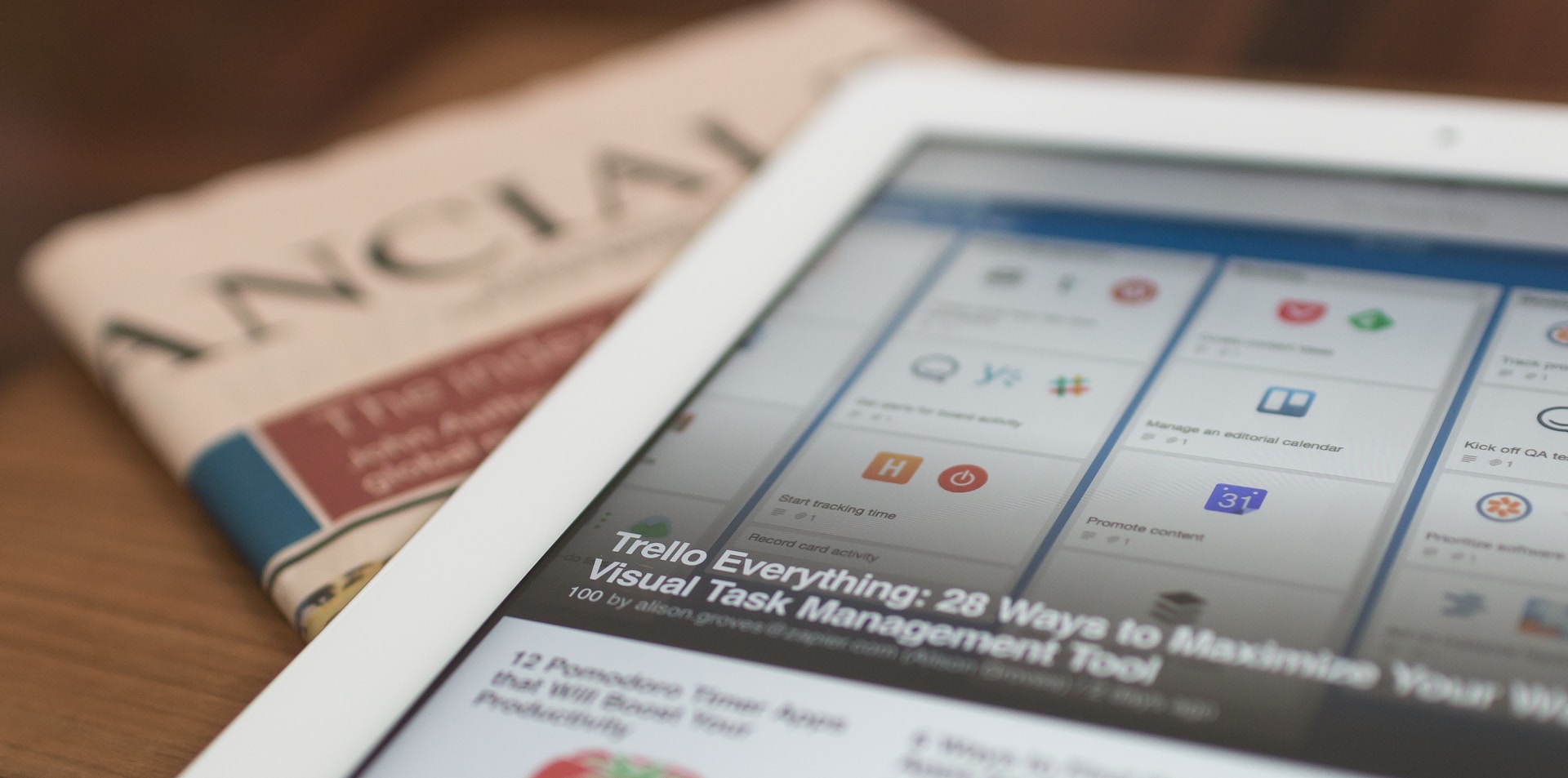 Tablet displaying news apps beside a printed newspaper